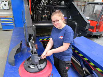 Stangl Lehrling Mechatronik Antonia Binder bei der Wartung einer Kehrsaugmaschine