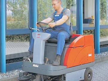 Der Seitenbesen der Aufsitz-Kehrmaschine Hako Sweepmaster 980-R von Stangl arbeitet der großen Kehrwalze zu