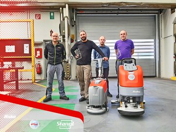 Mitarbeiter bei der Übergabe von zwei Bodenreinigungsmaschinen von Stangl 