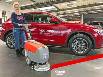 Mitarbeiterin eines Autohauses bei der Übergaben der Hako Bodenreinigungsmaschine B12 von Stangl