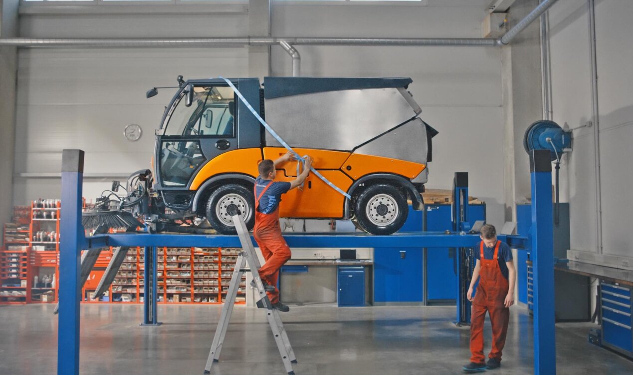 Kommunaltechnik Kundendienst Werkstatt Mitarbeiter reparieren Kehrmaschine