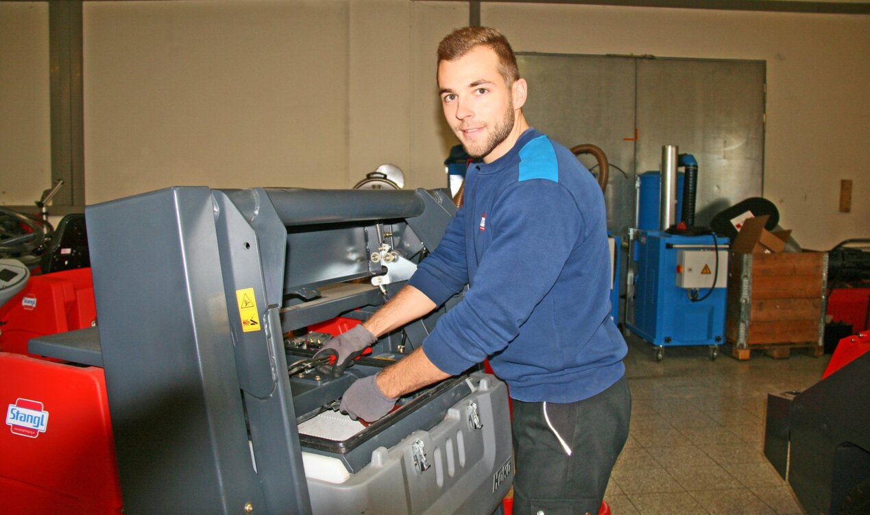 Stangl Kundendienst Mitarbeiter wartet eine Kehrmaschine