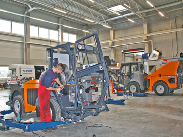 Stangl Werkstatt Kommunaltechnik ein Mitarbeiter repariert eine Kommunalmaschine