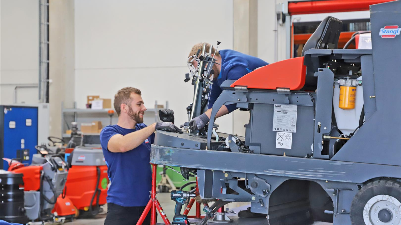 Zwei Stangl Kundendienst Techniker reparieren eine Kehrmaschine