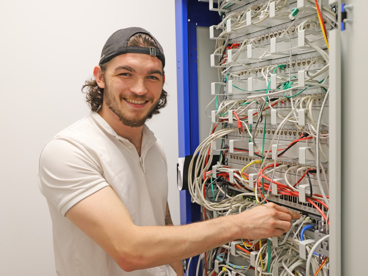 Stangl Lehrling IT Systemtechnik Sebastian Herlbauer vorm Serverschrank