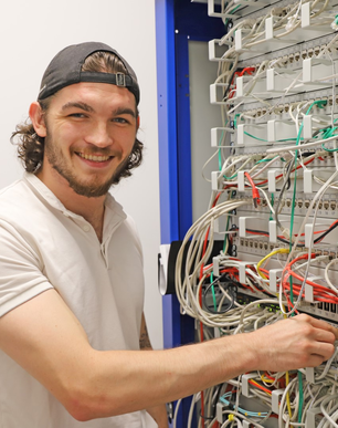 Stangl Lehrling IT Systemtechnik Sebastian Herlbauer vorm Serverschrank